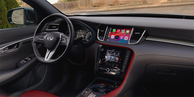 Interior of a 2025 INFINITI QX50 showing the dashboard, steering wheel, and dual screens with apps.