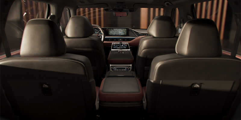Interior view of a modern INFINITI SUV showing leather seats and a large dashboard display.